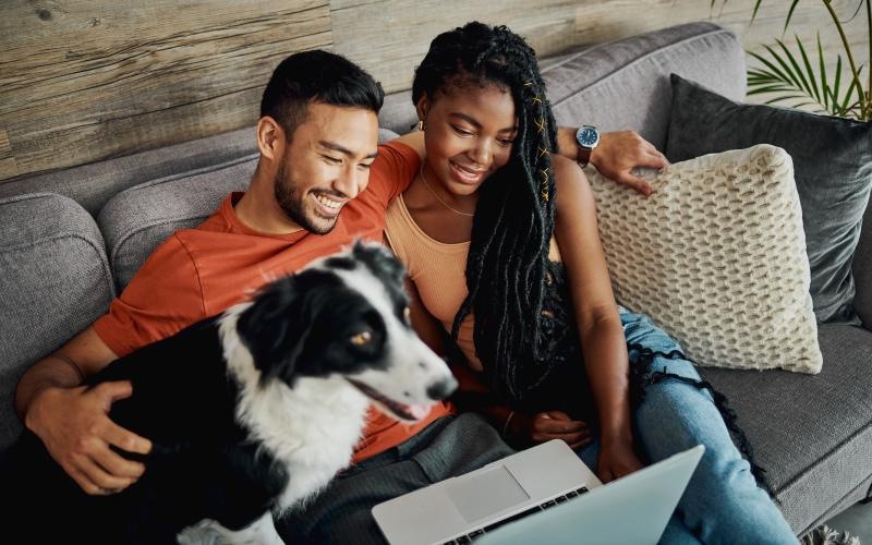a man and woman sitting on a couch with a dog