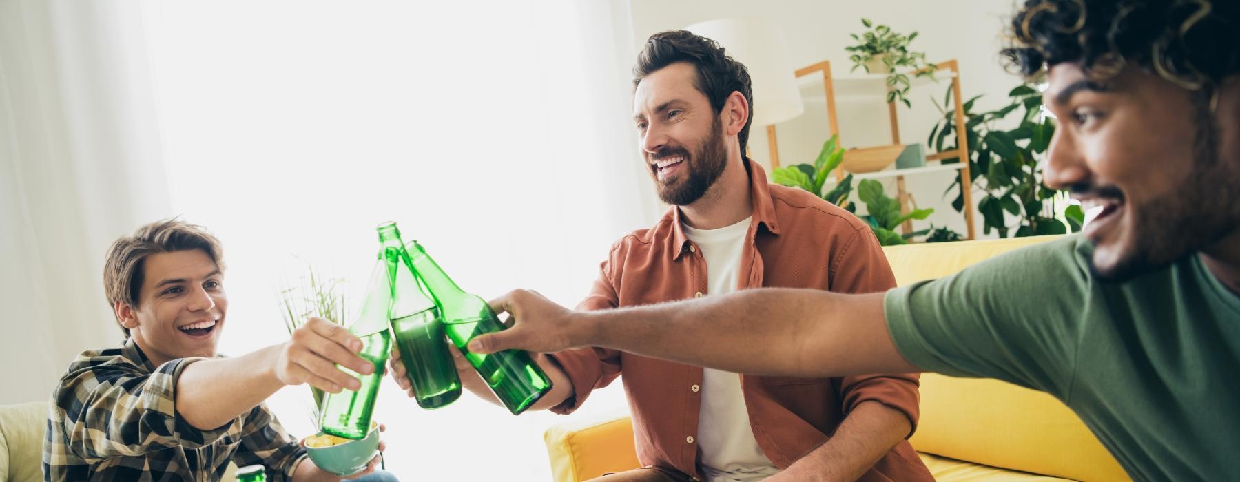a group of people sitting on a couch with food and drinks