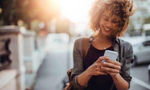 Find your perfect fit at Skyline Towers woman texts on her phone as she walks through the city