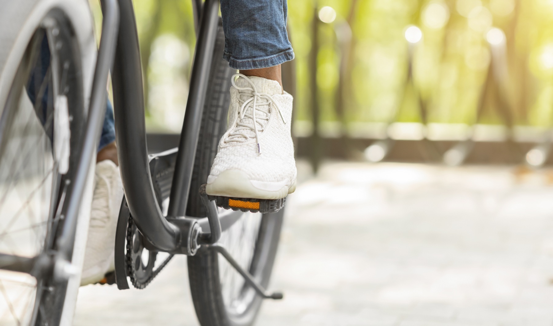 Feet On Pedals Of Person Riding Bicycle In Park