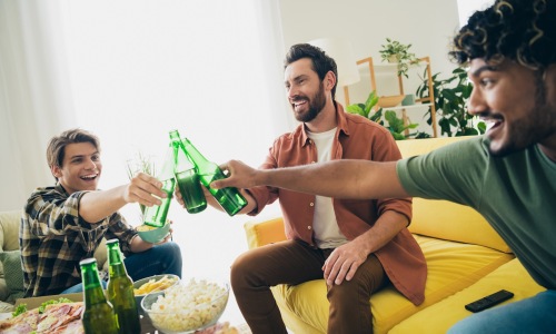 people with beer bottles in a living room