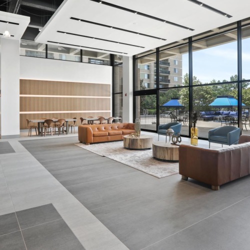 a large modern building with a glass front and a patio area